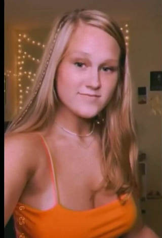 4. Titillating Caiti Mackenzie Shows Cleavage in Orange Crop Top