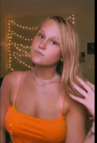 5. Titillating Caiti Mackenzie Shows Cleavage in Orange Crop Top