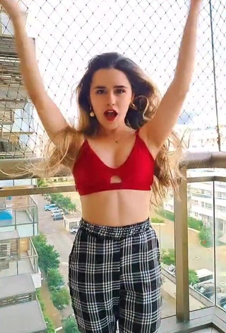 6. Luscious Letícia Pedro Shows Cleavage in Red Sport Bra on the Balcony